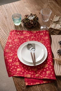 Gros plan du set de table de Noël rouge avec flocons dorés et vaisselle rustique