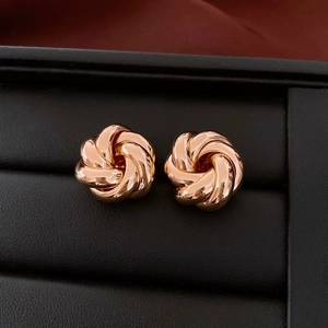 Close-up of rose gold hollow swirl knot stud earrings in a premium black jewelry box