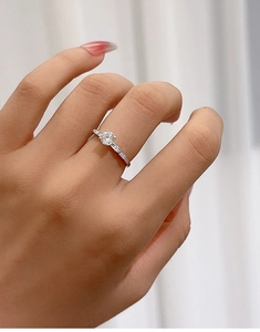 Macro detail of a 5mm Moissanite petal ring in 925 sterling silver on a finger