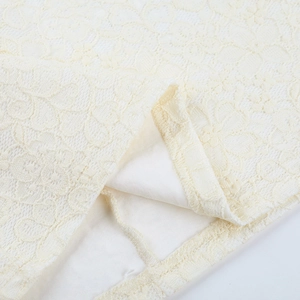 Vue macro détaillée du tissu en dentelle florale blanc cassé avec doublure assortie