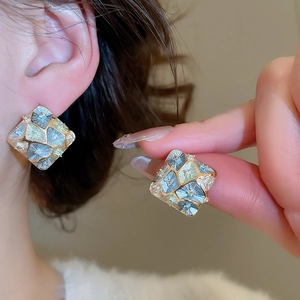 Detail of vintage geometric diamond earrings featuring multi-color gradient enamel finish
