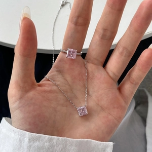 Close-up of S925 silver necklace and ring set featuring radiant-cut pink gemstones