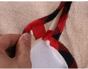 Detail of Christmas tree skirt with burlap fabric, red plaid edge and velcro closure