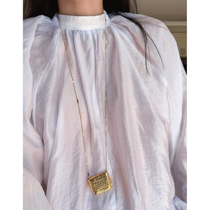 Long gold sweater chain with intricate woven texture metal pouch pendant necklace