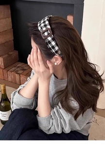 Gros plan du serre-tête à carreaux noir et blanc avec boucle marron vintage sur modèle