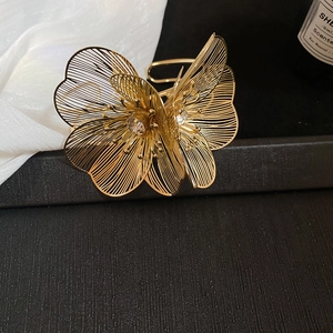 Detailed macro view of a golden hollow flower pendant with sparkling crystals and metal petals