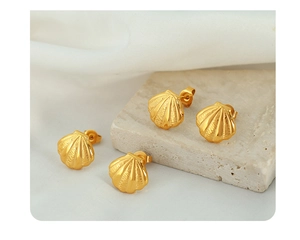 Detail of shell-shaped gold earrings with fine textures on natural stone background