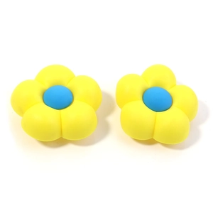 Detail of two yellow PVC floral charms with blue centers for beach bag customization