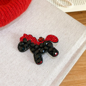 Close-up of red and black rhinestone horse hair clip on elegant textured fabric