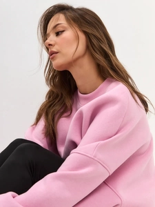 Close-up of pink crewneck sweatshirt texture and loose fit drop shoulder stitching detail
