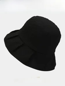 Detail showing the textured ruched fabric and wide brim of this black foldable sun hat