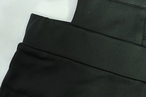 Gros plan sur le tissu en maille noire extensible et les coutures de la taille