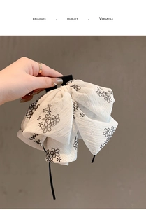Gros plan d'une pince à cheveux en tissu blanc avec motif floral élégant et raffiné