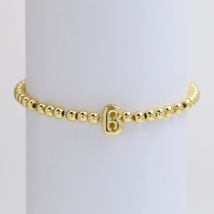 Elastic 18k gold plated beaded bracelet featuring a glossy letter B balloon charm