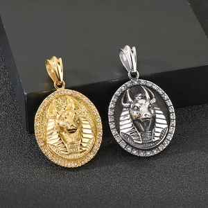 Vue détaillée de pendentifs Anubis or et argent avec strass sur un fond noir élégant