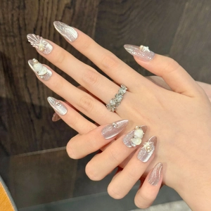 Detailed view of almond-shaped press-on nails with 3D seashells and pearls decor