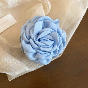 Nahaufnahme einer hellblauen Organza-Blume Haarklammer mit geschichteter Stofftextur