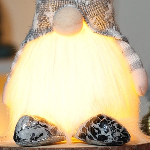 Macro detail of glowing Christmas gnome showing warm LED light and plush beard texture