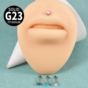 Détails macro des piercings labret en titane G23 avec opale en forme de cœur