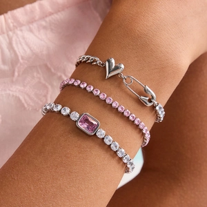 Three-piece silver and pink zircon bracelet set with heart pins on a model wrist