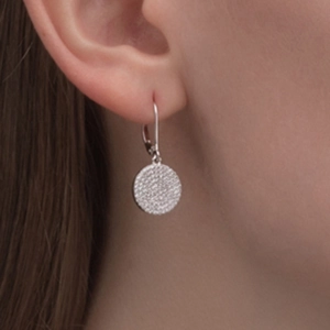 Close-up of elegant S925 sterling silver disk earrings with zircon pavé on model ear