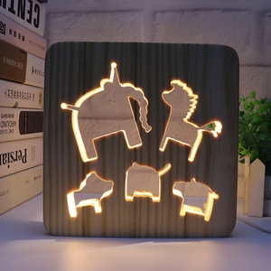 Detail of warm LED light shining through hollowed animal patterns in square wooden lamp
