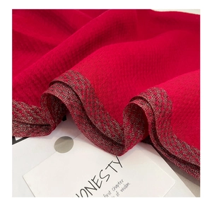 Macro view of red silk wool scarf texture with golden metallic sparkling edges