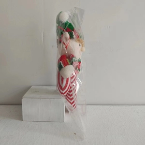 Detailed view of plush Christmas elf hanger in red and green festive theme packaging