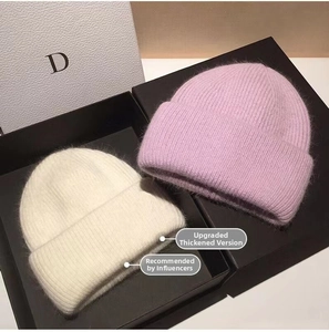 Detail of off-white and lavender rabbit fur knit beanies in a premium gift box set