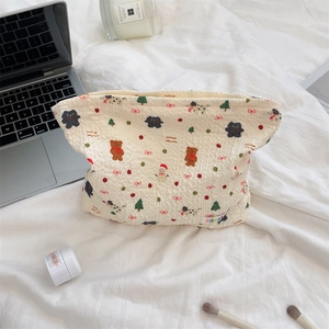 Detailed shot of white quilted Christmas bear makeup bag with festive prints