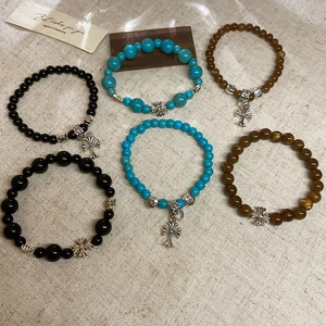 Détail de bracelets en perles vintage avec pendentifs croix rétro et perles d'espacement