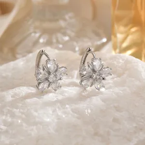 Elegant silver tulip earrings with cubic zirconia inlay on white textured stone background