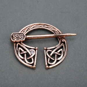 Macro shot of vintage bronze Celtic knot brooch with intricate woven metal texture