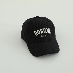 Gros plan de la broderie Boston sur casquette de baseball en velours côtelé noir texturé