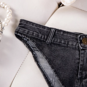 Dettaglio ravvicinato degli shorts in denim nero lavato elasticizzato con cuciture e bottone