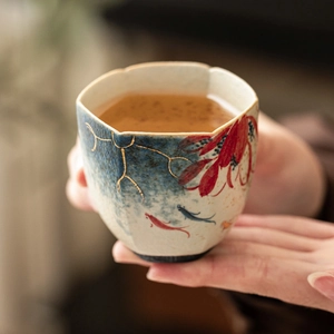 Hand-painted ceramic teacup with red lotus, koi fish design and gold accents