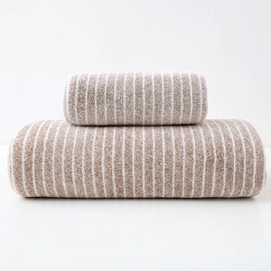 Detail of soft striped towel set in brown and white cotton fabric macro texture