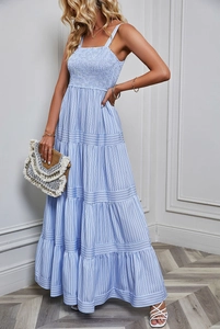 Detail of light blue striped summer dress featuring a layered tiered skirt and elastic waist