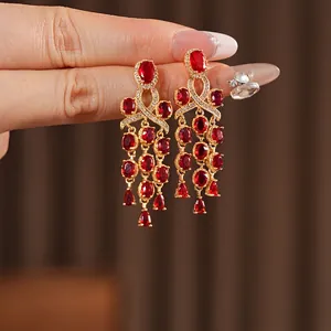 Vintage gouden hangende oorbellen met rode ovale edelstenen en elegante kwastjes