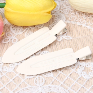 Close-up of beige metal painted hair clips on delicate lace with tulip accents
