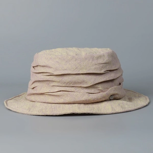 Detailed close-up of a distressed linen bucket hat with layered texture design