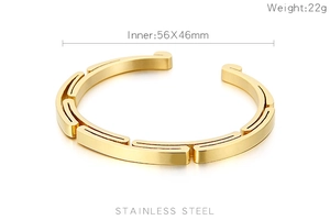 Detail view of gold stainless steel open bangle with geometric design and 56x46mm inner size