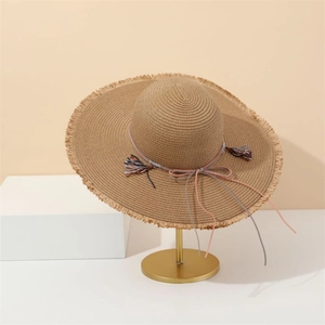 Detailed view of women's straw sun hat with colorful woven rope and tassel bow tie