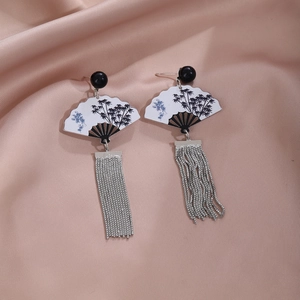 Detail of silver fan earrings with ink bamboo pattern and asymmetrical tassels on silk