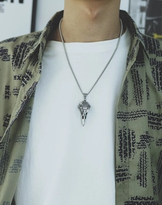 Close-up of Viking raven skull pendant with Nordic runes on a silver chain necklace