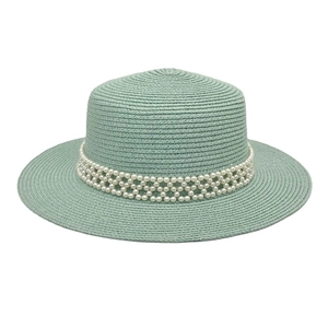 Close-up of mint green straw hat showing woven texture and pearl beaded band detail
