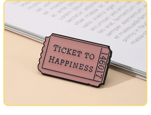 Detail of pink enamel pin ticket to happiness with polished black metal edges