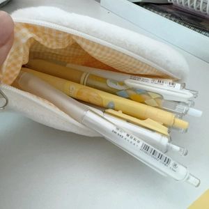 Macro shot of white plush pencil case with yellow checkered lining and large capacity