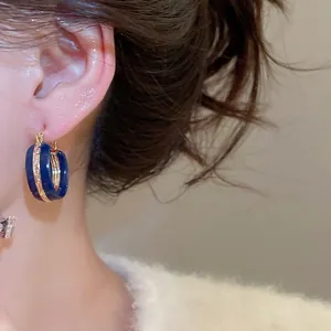 Minimalist vintage navy blue enamel and gold hoop earrings shown on model