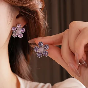 Boucles d'oreilles fleurs en argent avec cristaux violets et roses sur un mannequin